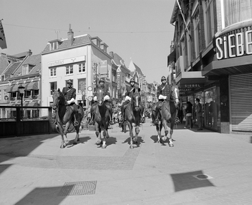 102761 Afbeelding van vier agenten van de bereden politie in gala-uniform, gevolgd door de Politiekapel, in de Lange ...